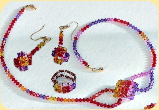 creare bigiotteria Swarovski collana orecchini anello cristalli rossi gialli arancioni rosa viola
