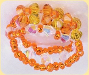 fare anello Swarovski arancioni gialli cristallo intreccio filo elastico motivo fiorellino